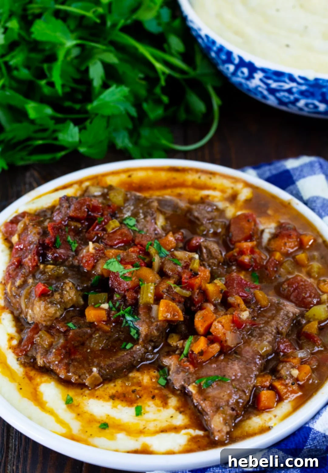 Fork Tender Slow Cooker Grillades 4 Slow Cooker Grillades served generously over creamy grits in a bowl.