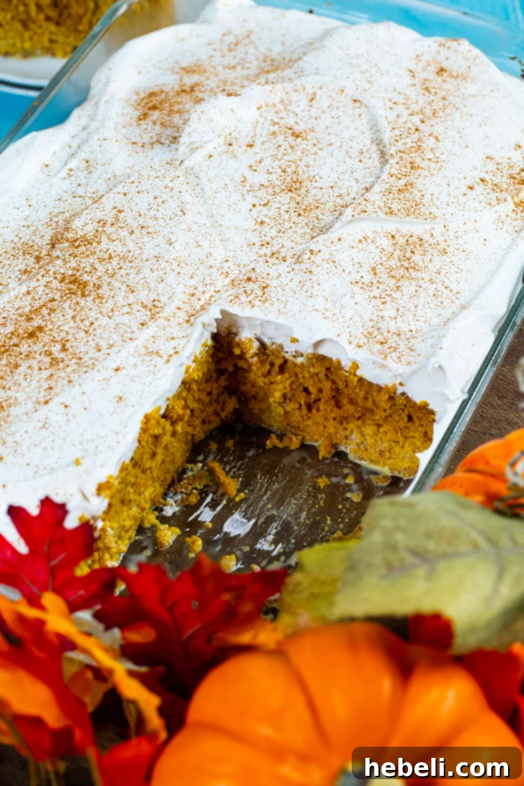 Spiced Pumpkin Tres Leches Cake 5 The fully assembled Pumpkin Tres Leches Cake, still in its baking dish, topped with whipped cream and a sprinkle of cinnamon.