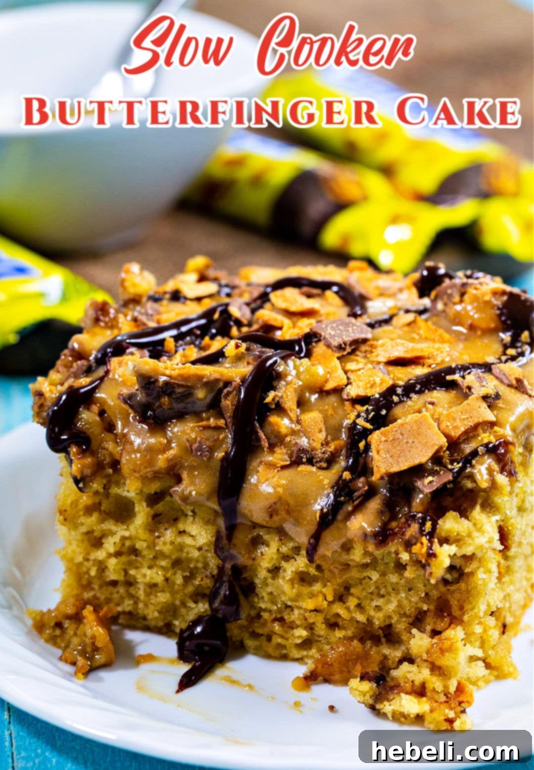 Crock Pot Butterfinger Cake 5 A slice of Slow Cooker Butterfinger Cake on a white plate, showcasing its moist texture and crunchy candy pieces.