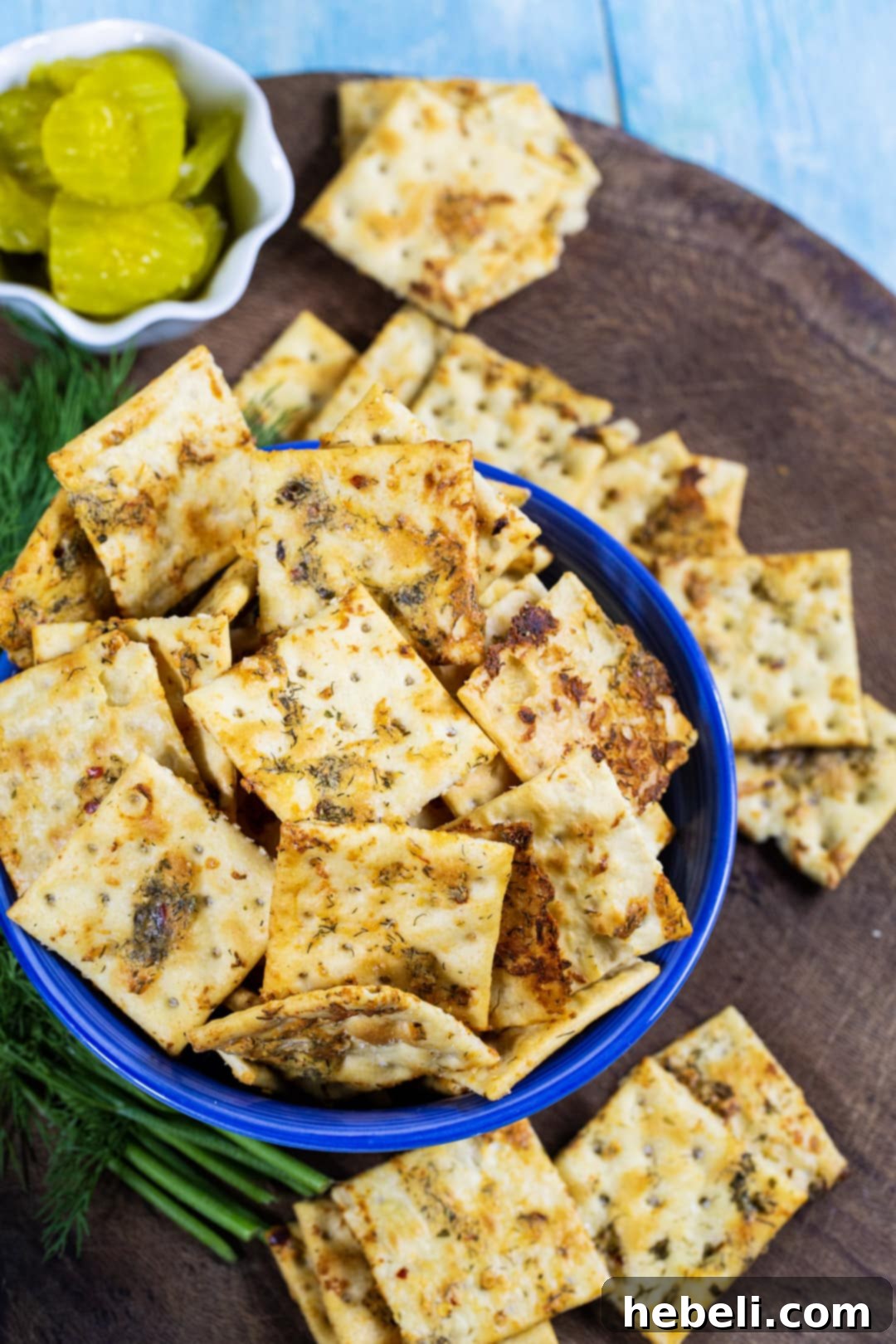 A close-up shot of delicious Dill Pickle Saltines in a rustic blue bowl, perfectly seasoned and ready to eat.