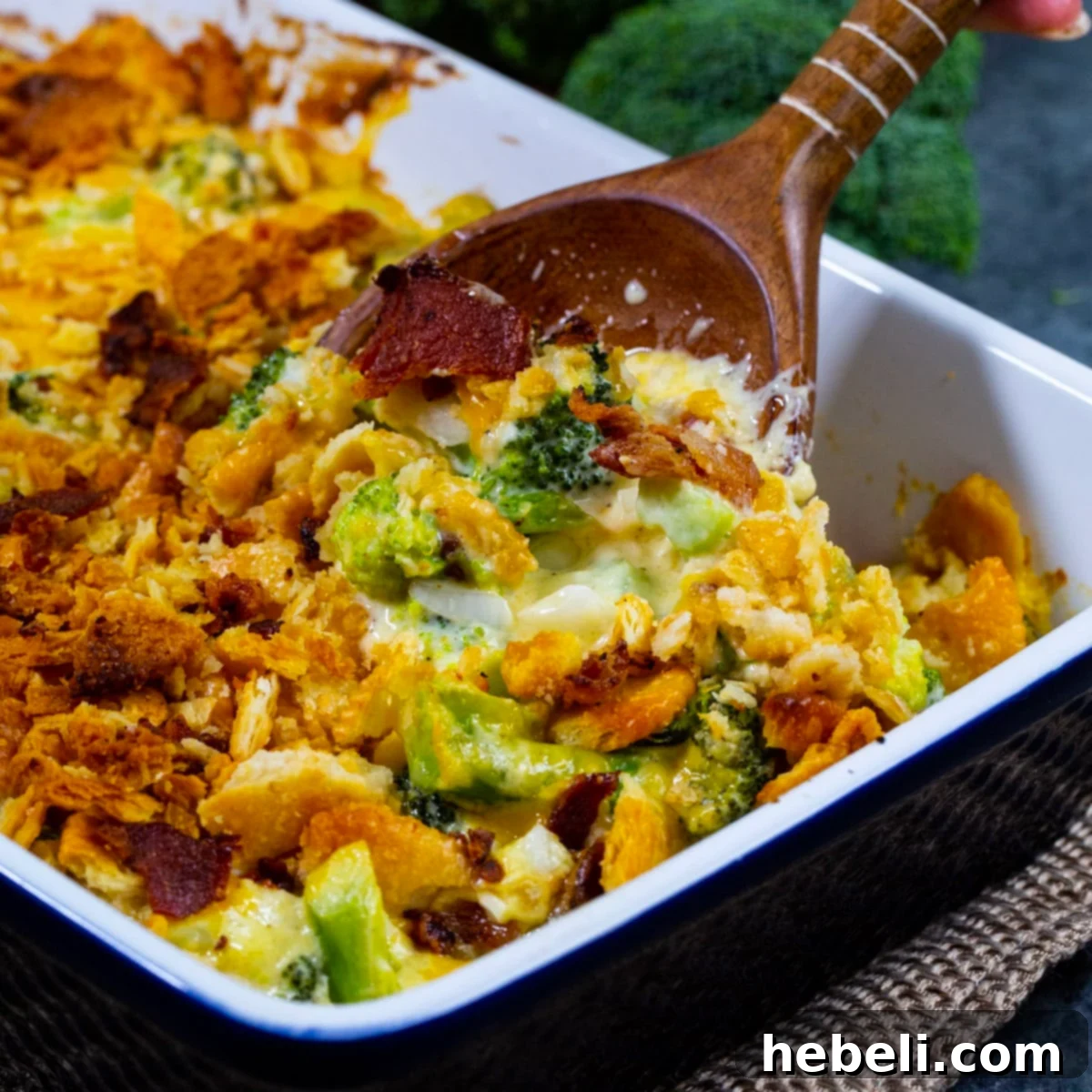 Spoon scooping Loaded Broccoli Casserole out of baking dish.