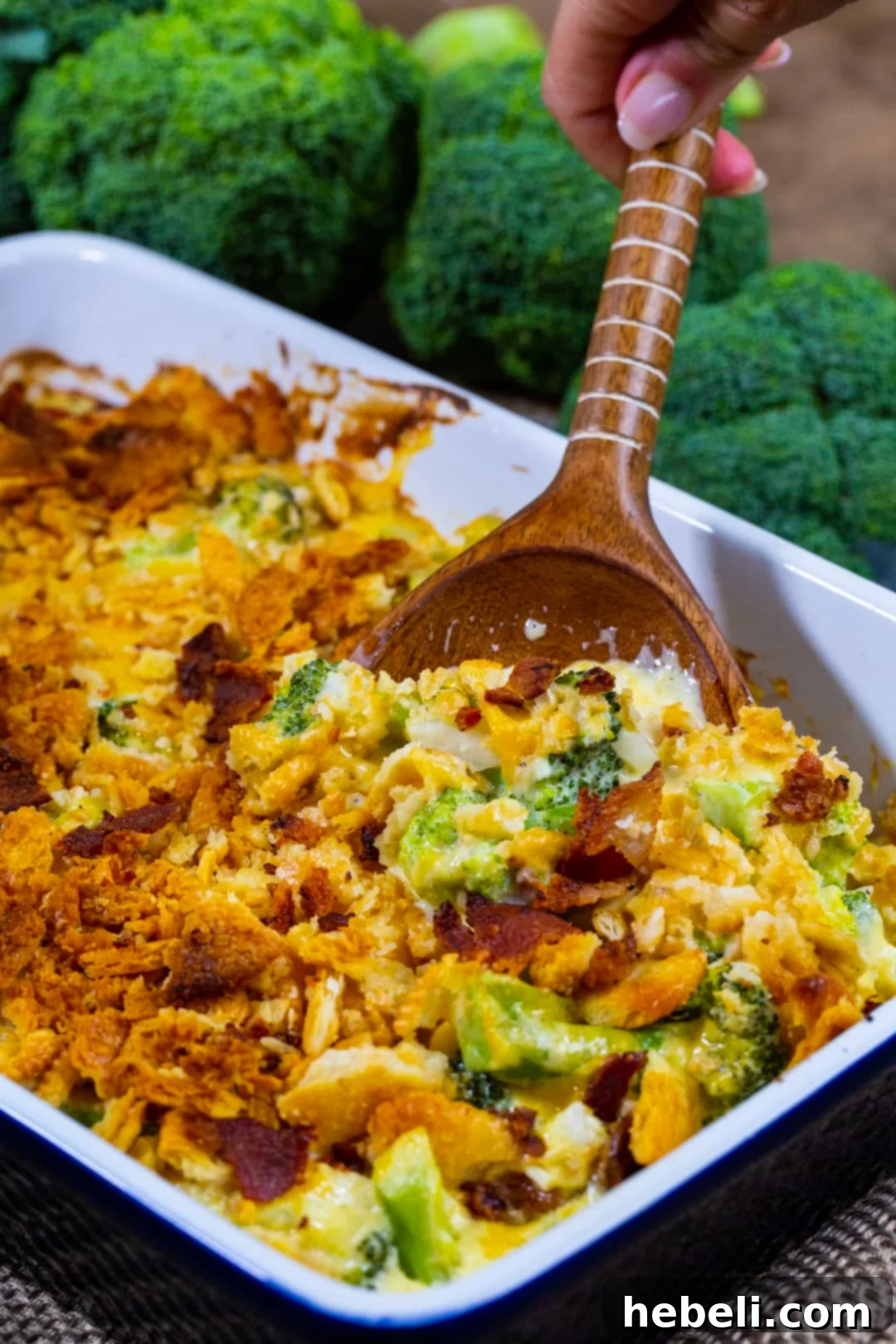 Wooden spoon scooping Loaded Broccoli Casserole.