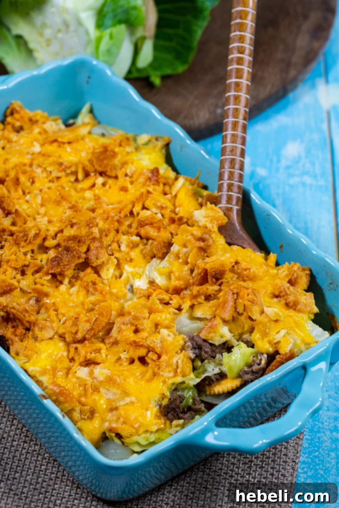 Comforting Beef and Cabbage Casserole 5 A serving spoon lifting a generous portion of Cabbage Ground Beef Casserole, showcasing its creamy layers and crispy topping.
