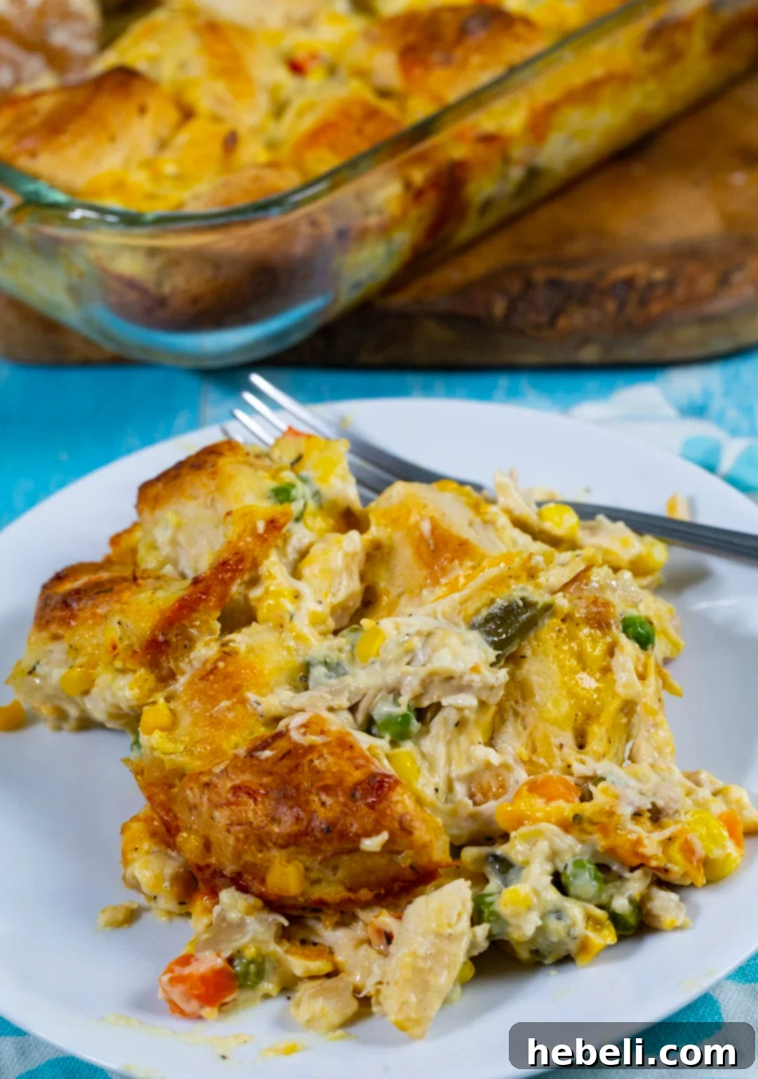 Fluffy-Topped Chicken Pot Pie Casserole 7 A serving of Chicken Pot Pie Bubble Up casserole dished up on a clean white plate, showcasing the creamy filling, vegetables, and golden biscuit pieces.