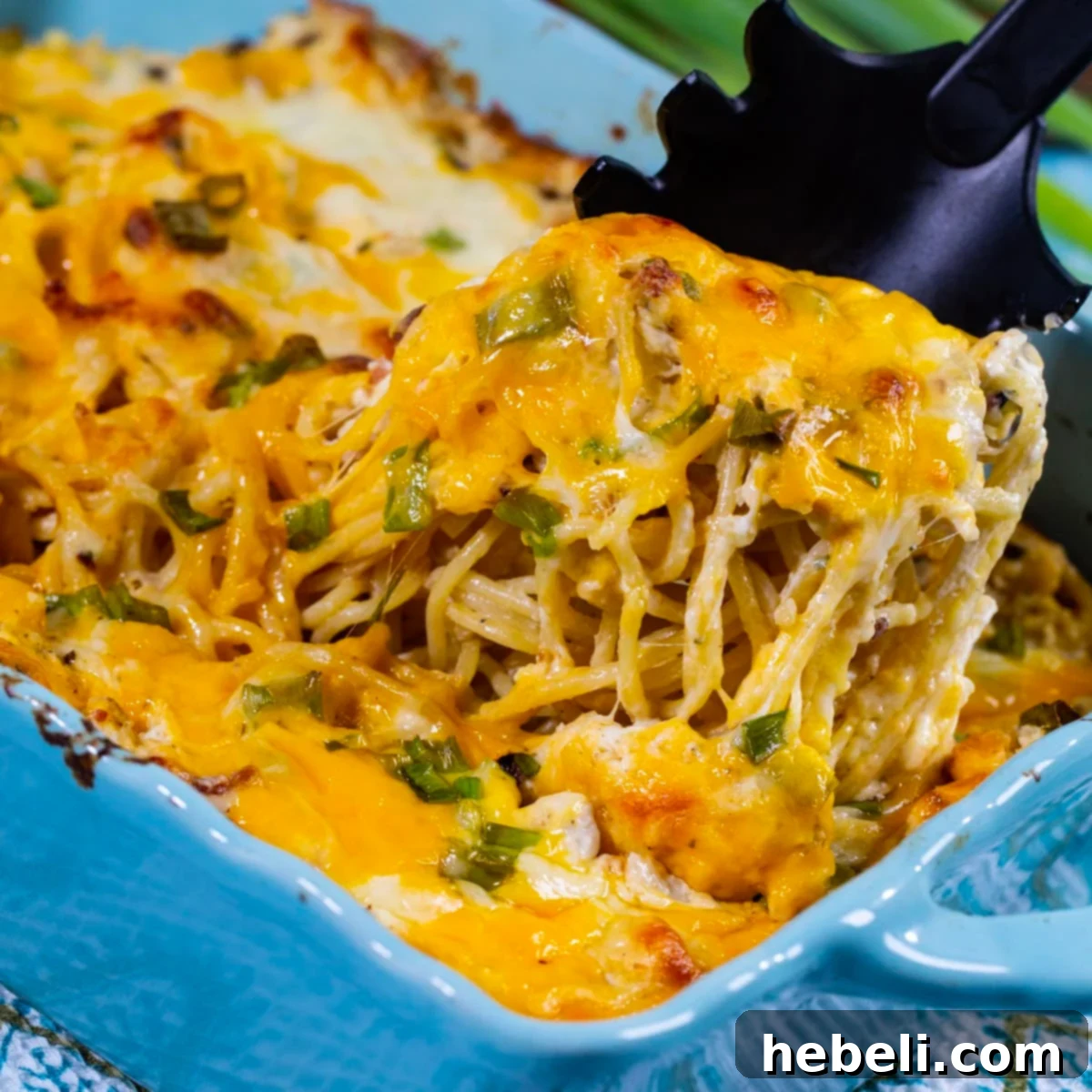 Crack Chicken Spaghetti being scooped out of a casserole dish, highlighting its creamy texture and rich ingredients.
