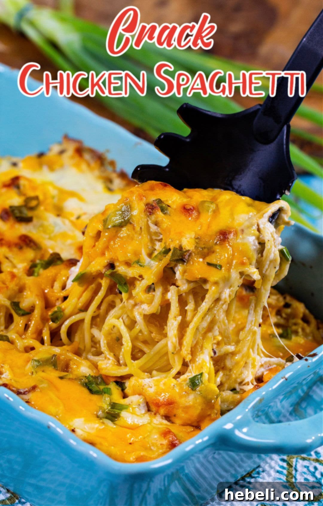 A portion of Crack Chicken Spaghetti being lifted from a casserole dish, showcasing the creamy pasta and melted cheese.