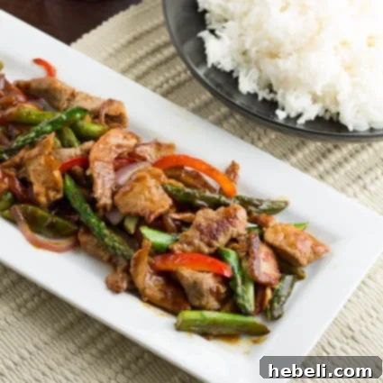 Savory Garlic Pork Stir-Fry 2 Delicious Pork and Asparagus Stir-Fry served on a white rectangular platter, ready to enjoy.