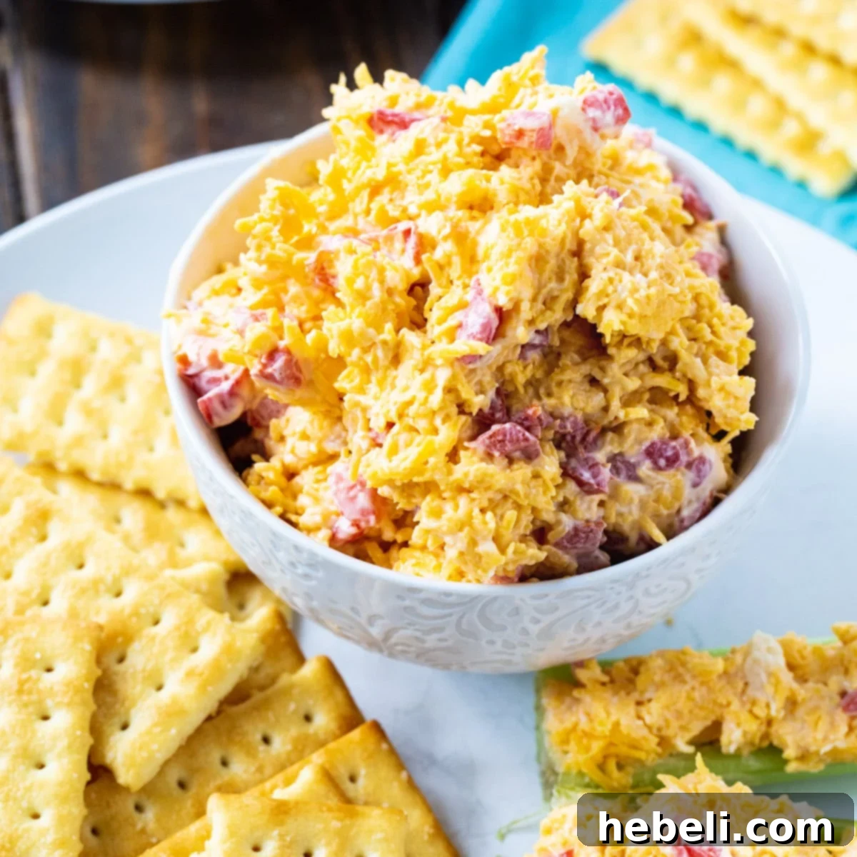 Southern Pimento Cheese Perfection 2 Pimento Cheese in a rustic white bowl surrounded by crispy club crackers, ready to be served as a quintessential Southern appetizer.