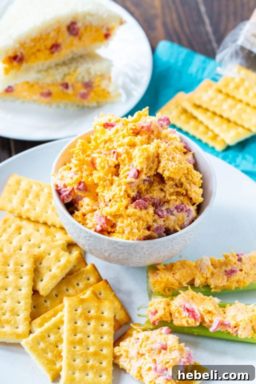 Southern Pimento Cheese Perfection 3 A large bowl of homemade Pimento Cheese, perfectly creamy and ready to be served, surrounded by various crackers for easy dipping.