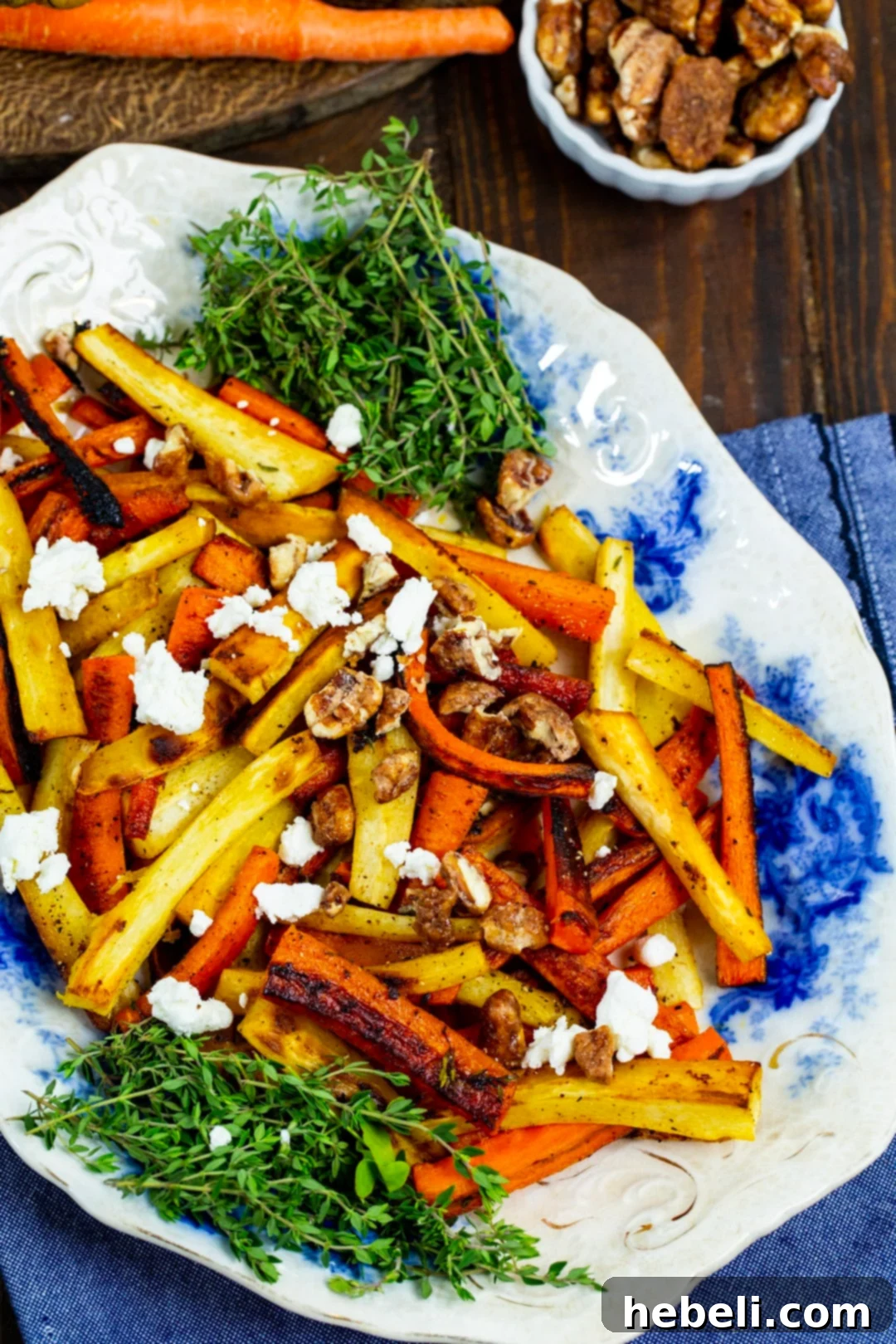 A large serving plate filled with golden-brown roasted carrots and parsnips, glistening from the maple glaze, ready to be adorned with toppings.