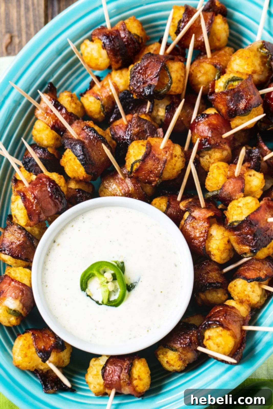 A generous serving of crispy Jalapeño Bacon Tater Tots presented beautifully with a bowl of homemade ranch dipping sauce, ready for an appetizer spread.