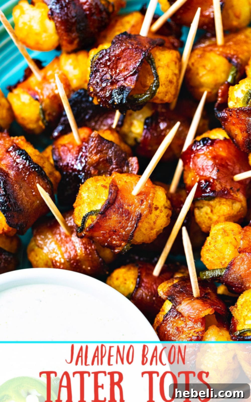 A top-down view of several crispy Jalapeño Bacon Tater Tots arranged artfully on a white serving plate, highlighting their golden texture and the visible jalapeño slices wrapped in bacon.