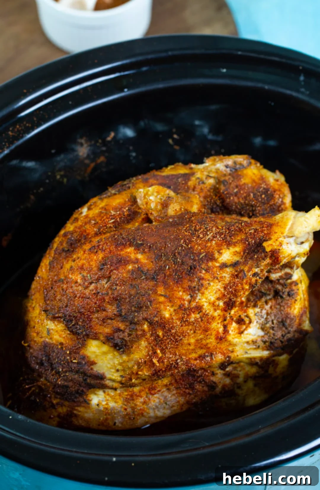 Tender Cajun Slow Cooker Turkey 3 A perfectly cooked turkey breast nestled in a slow cooker, surrounded by aromatic vegetables and rich juices, ready for the next step.