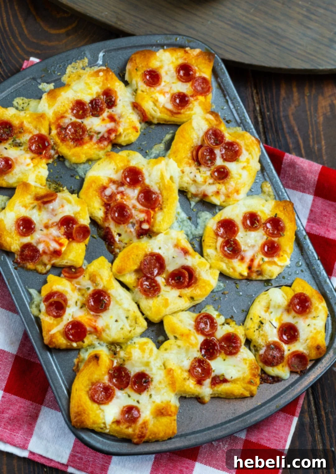 Cheesy Pepperoni Pizza Bites 3 A close-up view of unbaked Pepperoni Pizza Poppers in a mini muffin tin, showcasing the crescent roll dough bases perfectly shaped.