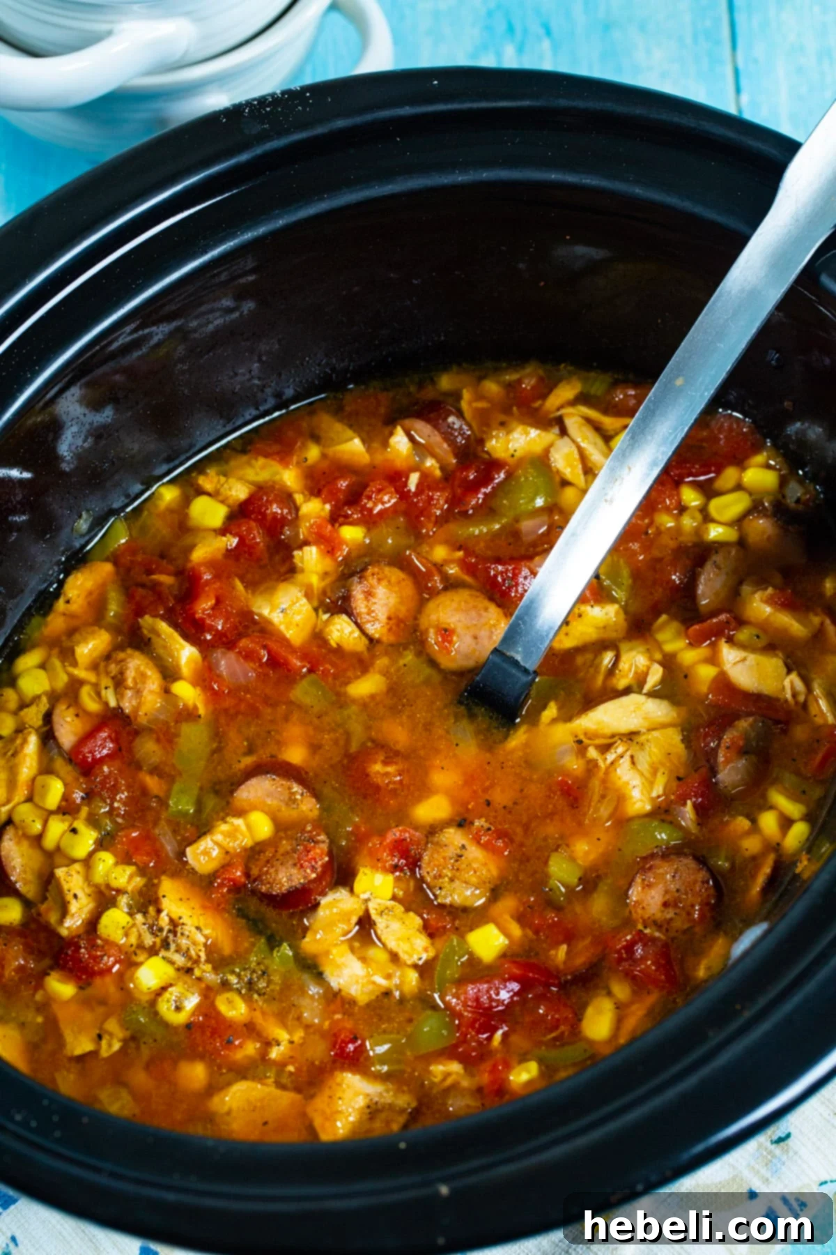 Slow Cooker Cajun Turkey Soup in a crockpot, close up view showing the rich broth and ingredients.