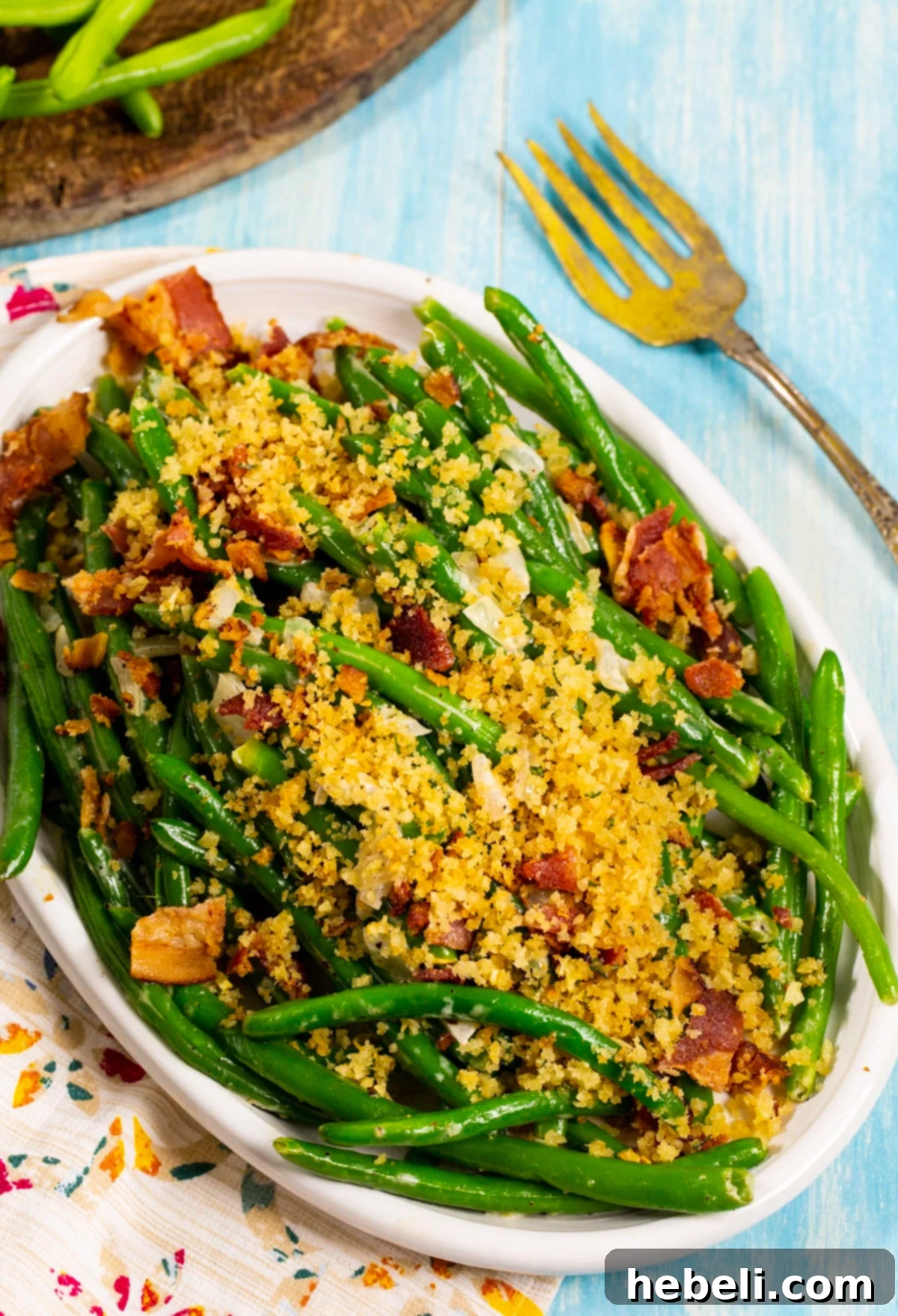 Crispy Bacon Green Beans 3 Green beans on a serving platter, beautifully topped with golden Panko crumbs and savory bacon pieces.