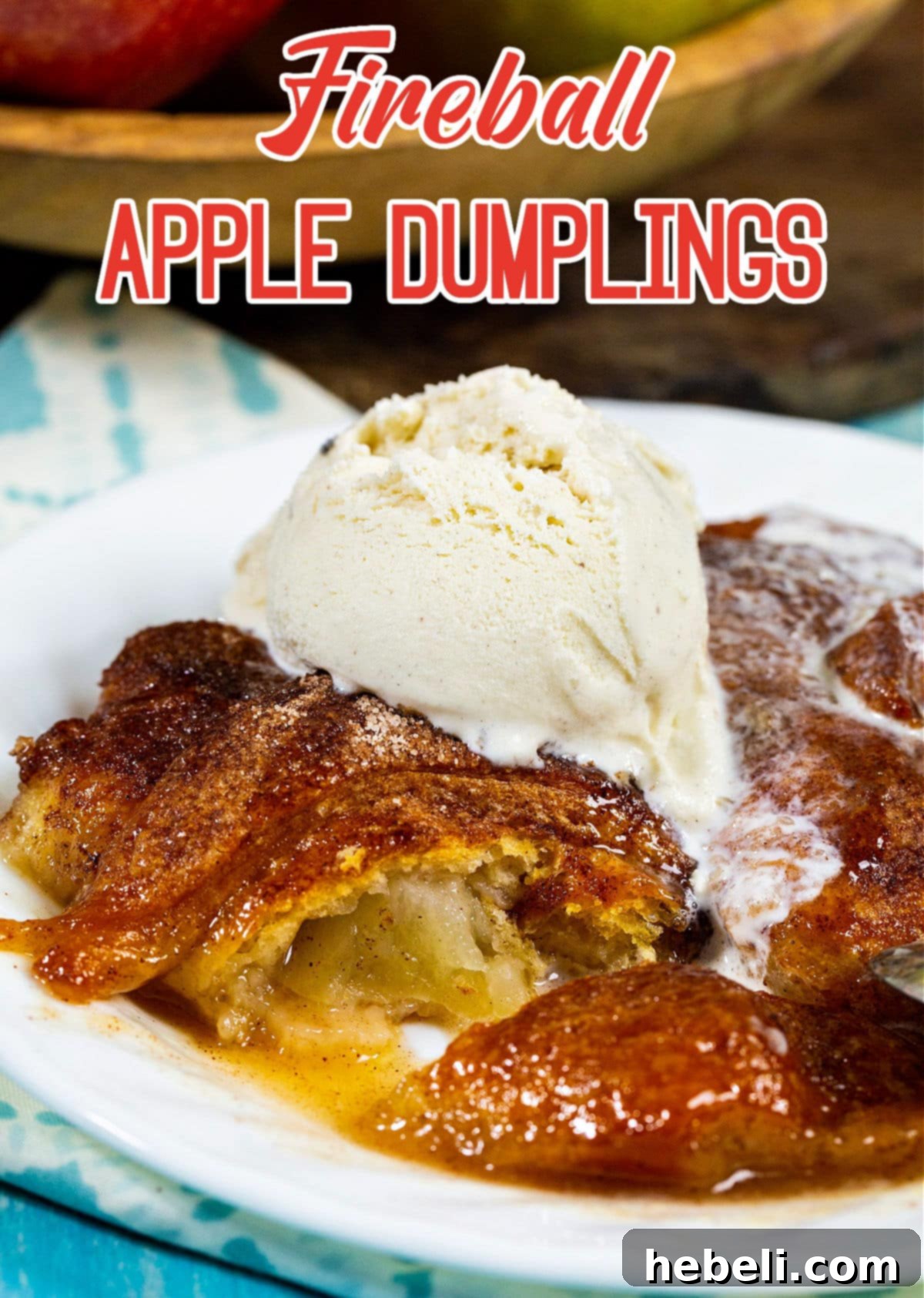 Blazing Apple Dumplings 5 Overhead view of several Fireball Apple Dumplings in a white baking dish, generously topped with melting vanilla ice cream and surrounded by spicy caramel sauce.