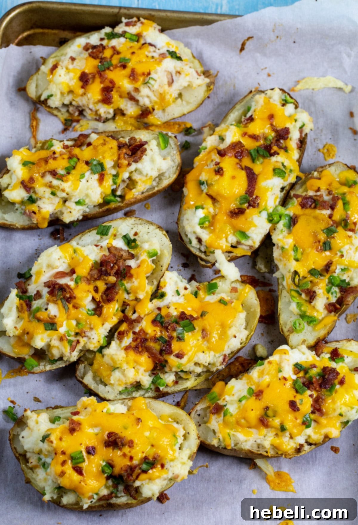 Stuffed potato halves arranged neatly on a baking sheet, ready for the second bake.