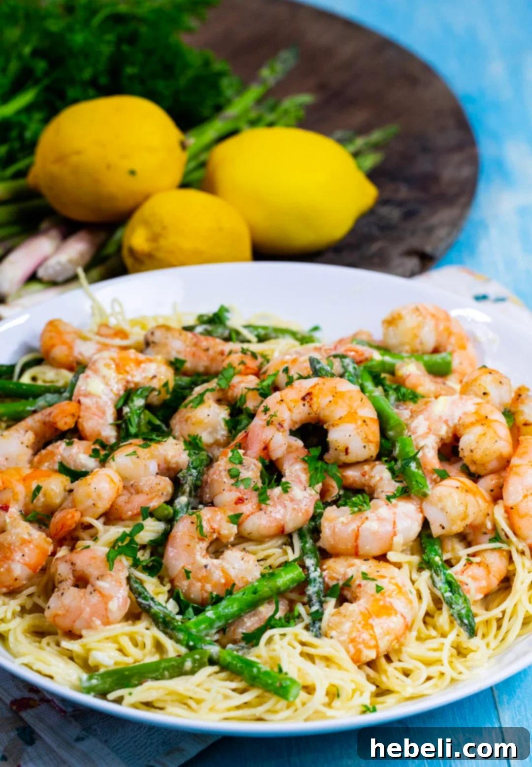 Zesty Lemon Shrimp Pasta 4 Shrimp Angel Hair Pasta in bowl and fresh lemons in background.
