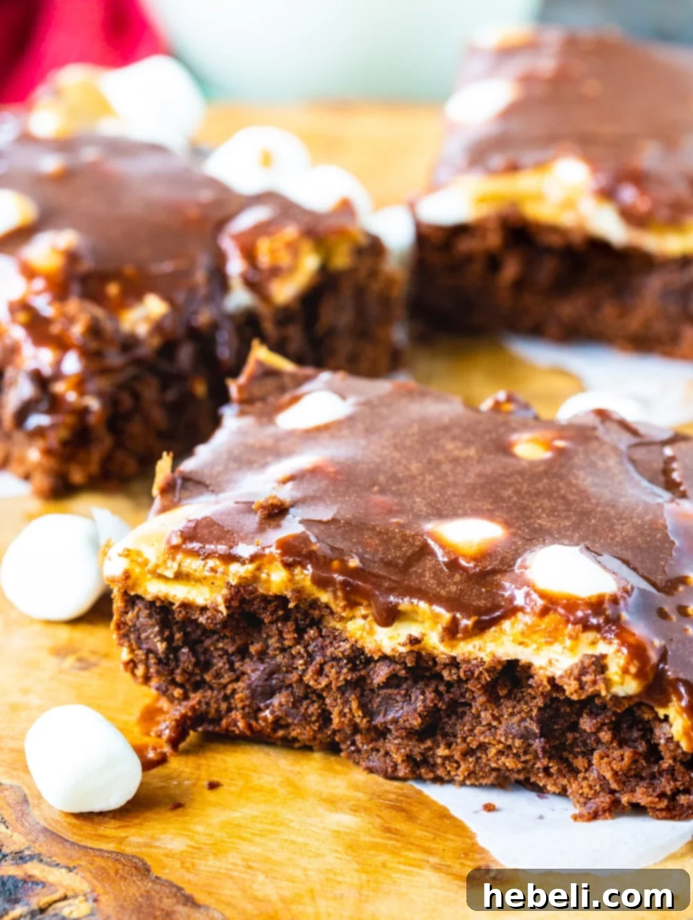 A close-up of a Peanut Butter Mississippi Mud Brownie slice on a cutting board, highlighting the various delicious layers.