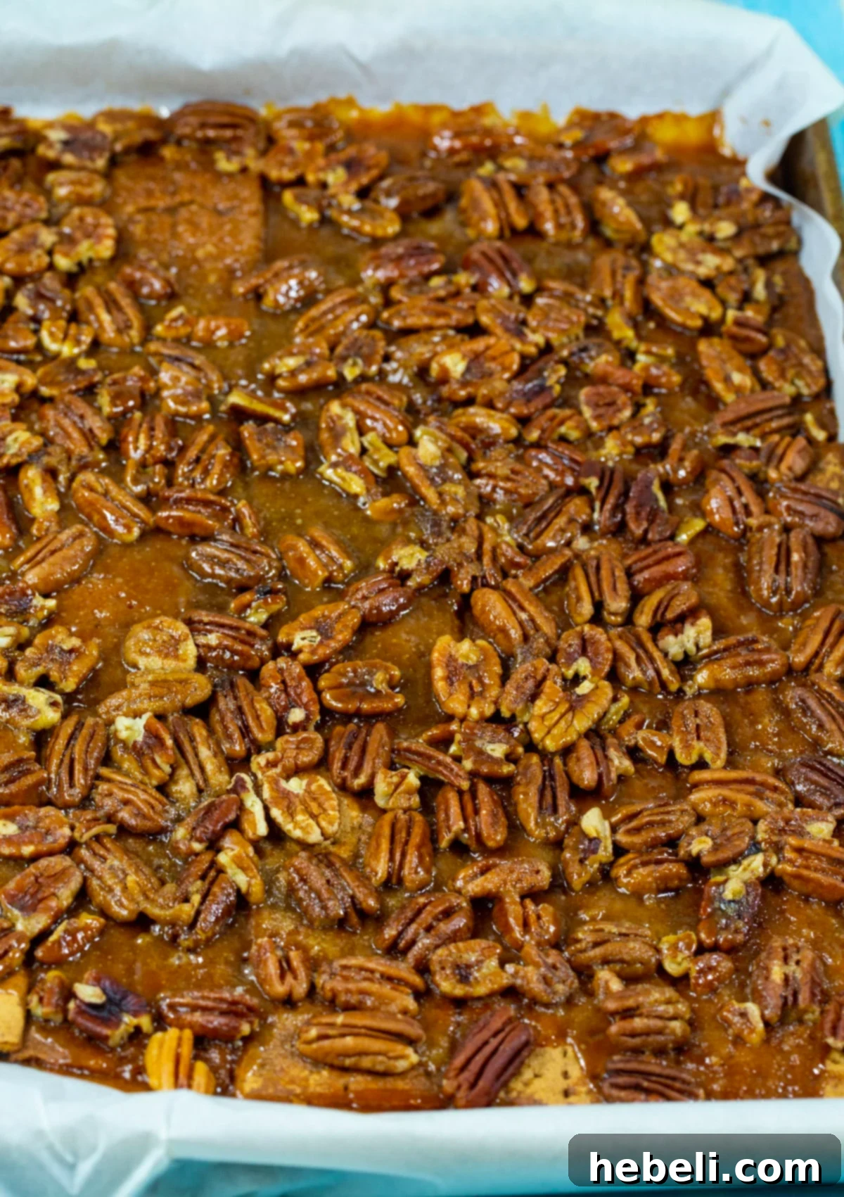 Finished Pecan Pie Bark on a baking sheet before being broken into pieces, showing its golden-brown top.