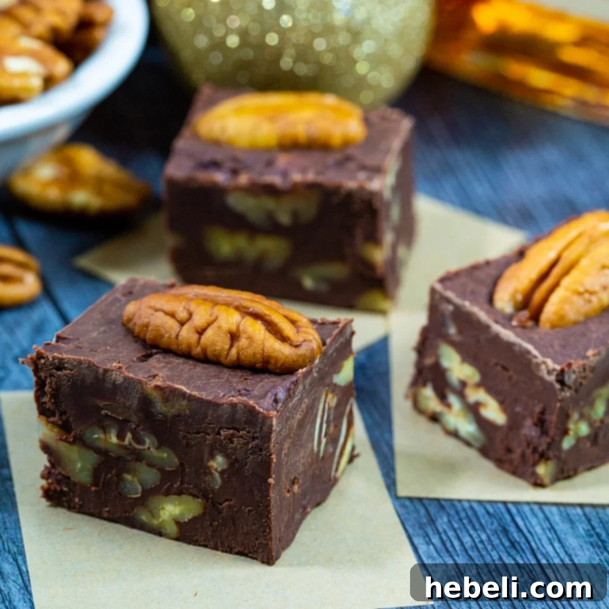 Decadent Bourbon Pecan Fudge 2 Bourbon Pecan Fudge pieces topped with pecan halves, showcasing the rich texture.
