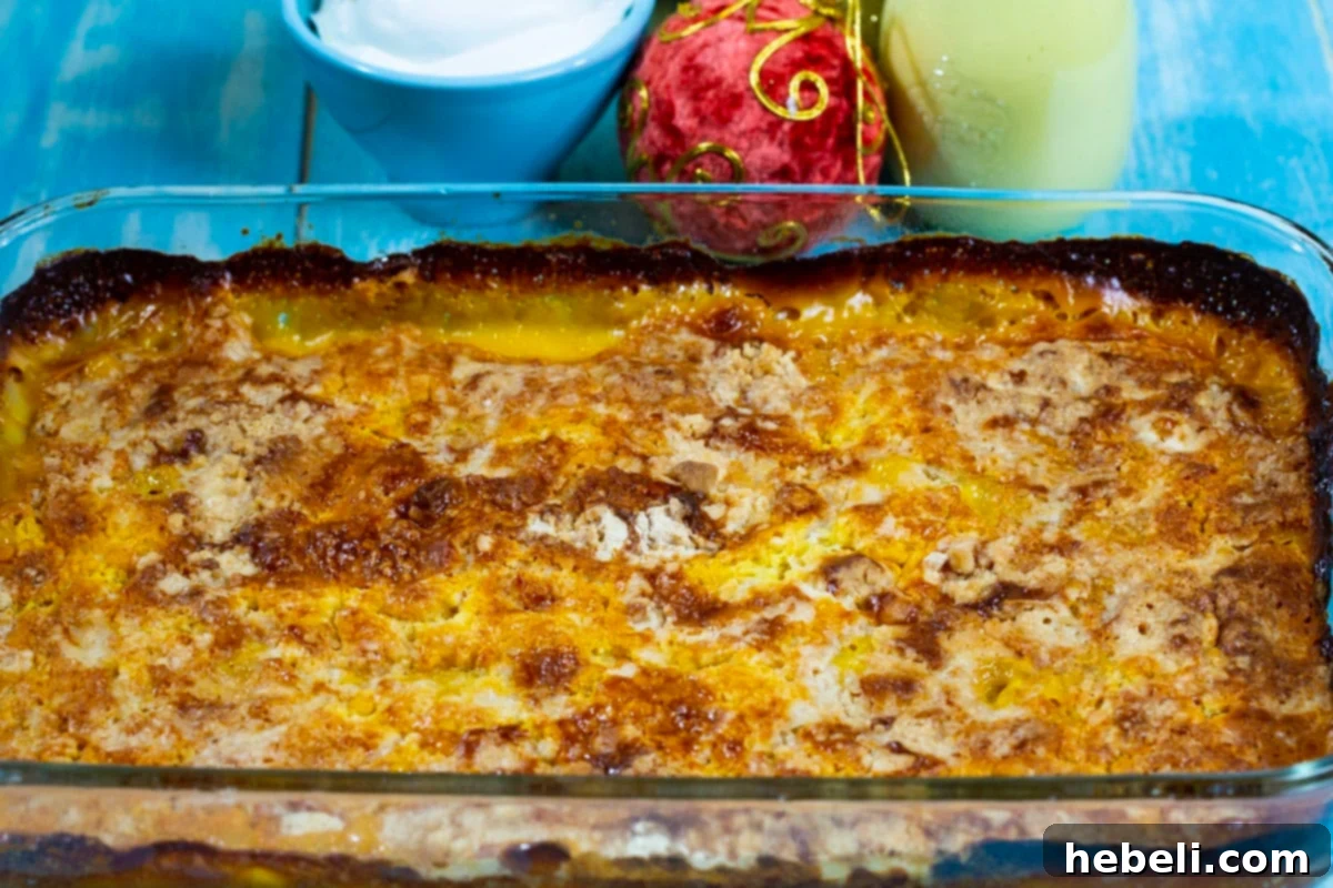 A warm, golden 3-Ingredient Eggnog Dump Cake baking in a 9x13-inch dish, showcasing its bubbly, inviting texture.