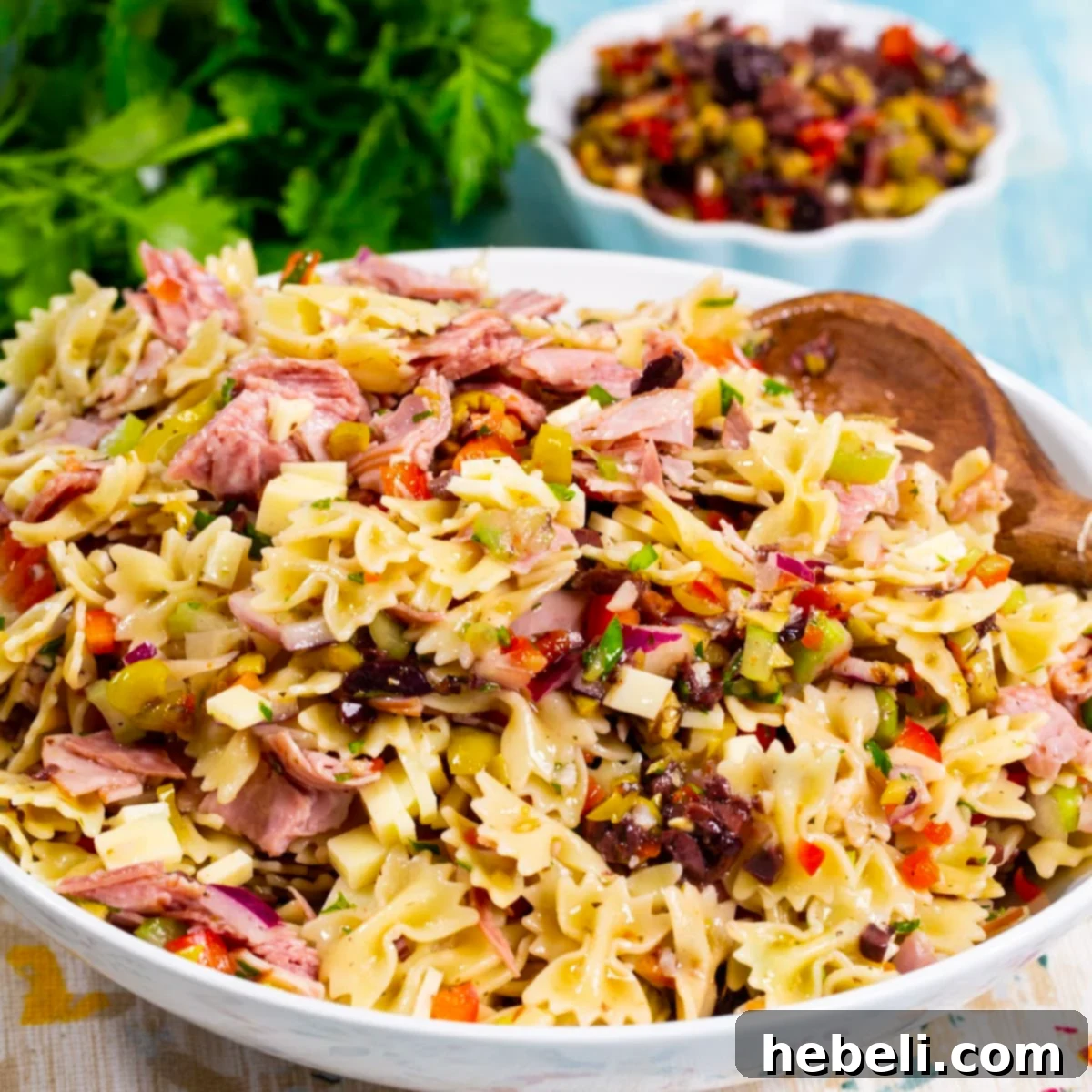 Zesty Muffaletta Pasta Salad 2 Vibrant Muffaletta Pasta Salad served in a elegant white bowl, showcasing its rich colors and textures.