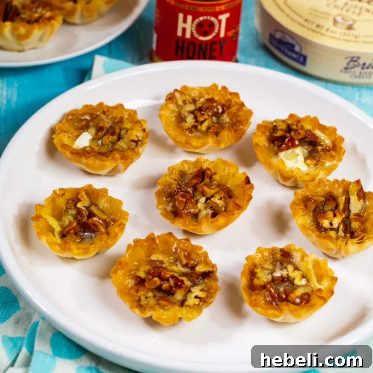 A plate of exquisite Bourbon Pecan Brie Bites, garnished and ready to be served as a delightful appetizer.