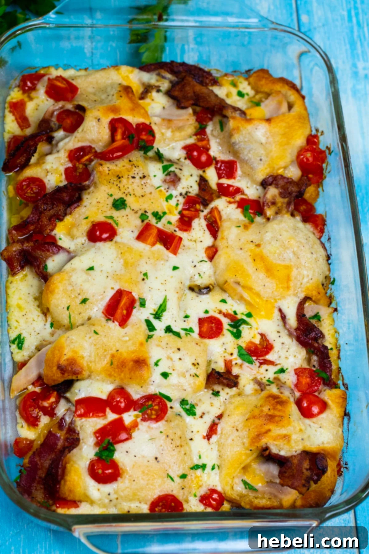 Kentucky Hot Brown Crescent Bake 3 Close-up view of the golden-brown Hot Brown Crescent Casserole in a baking dish, highlighting the melted cheese and visible crescent roll peaks.