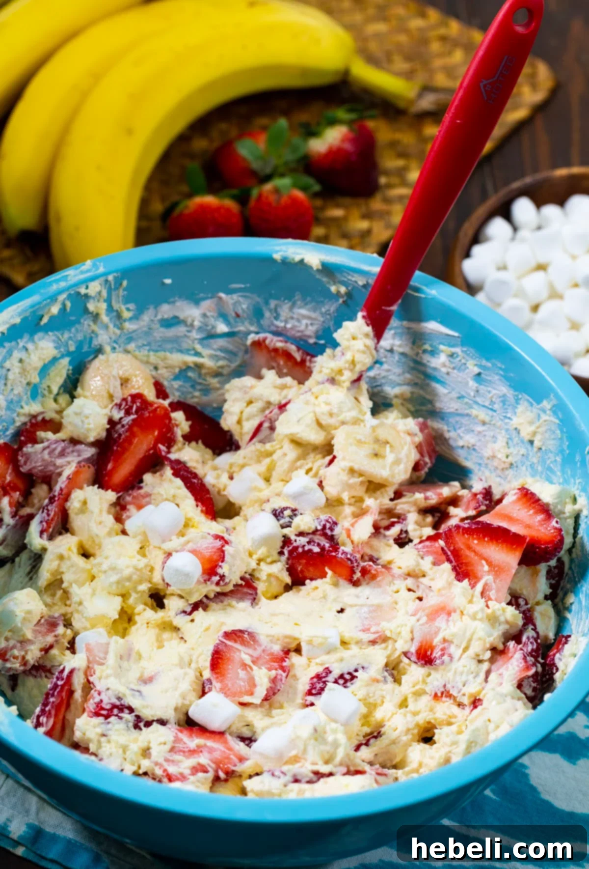 Cheesecake Salad mixture being prepared in a large mixing bowl, showcasing the creamy base.