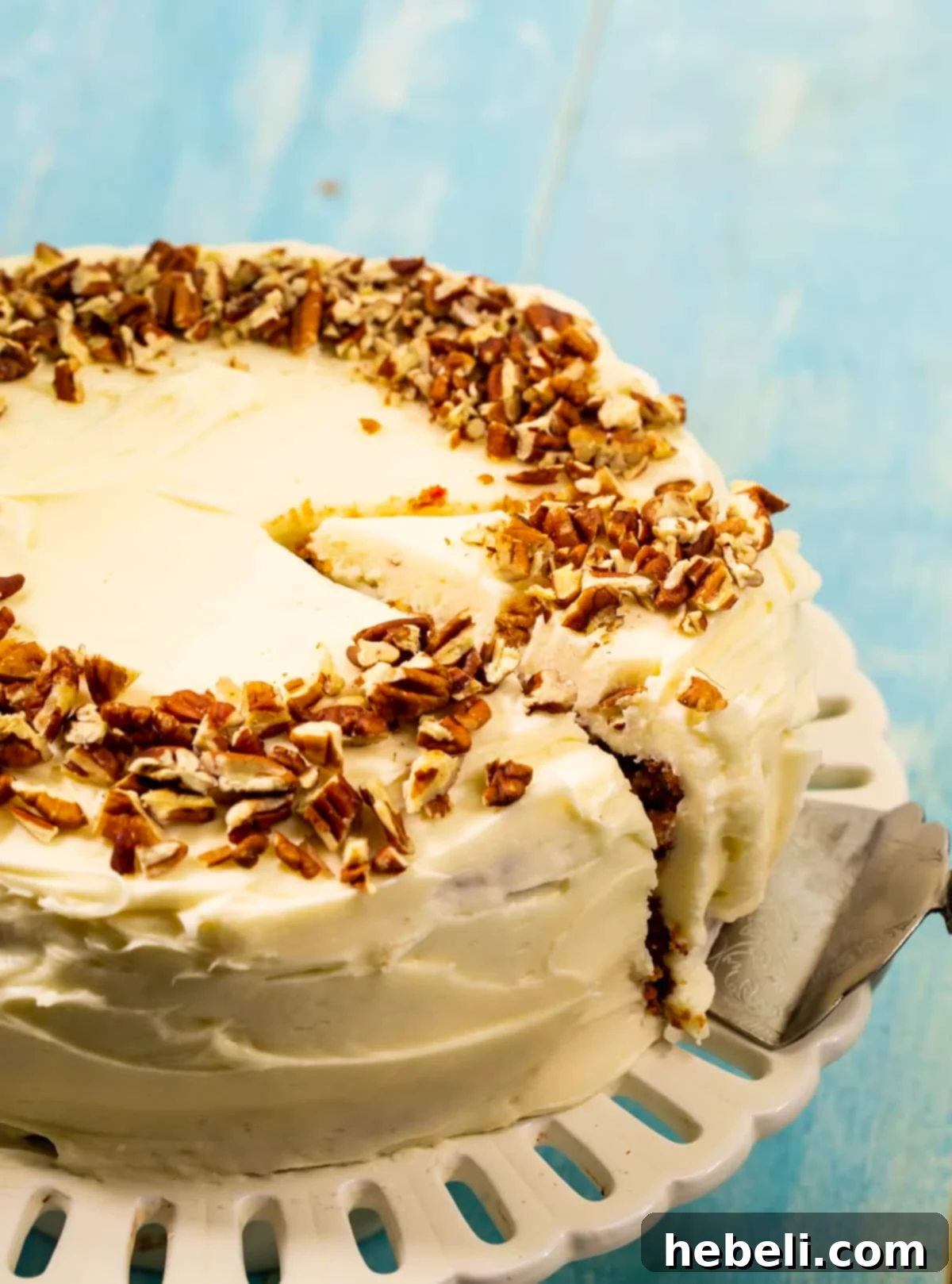 Easy Carrot Cake beautifully decorated with cream cheese frosting, presented on a cake stand.