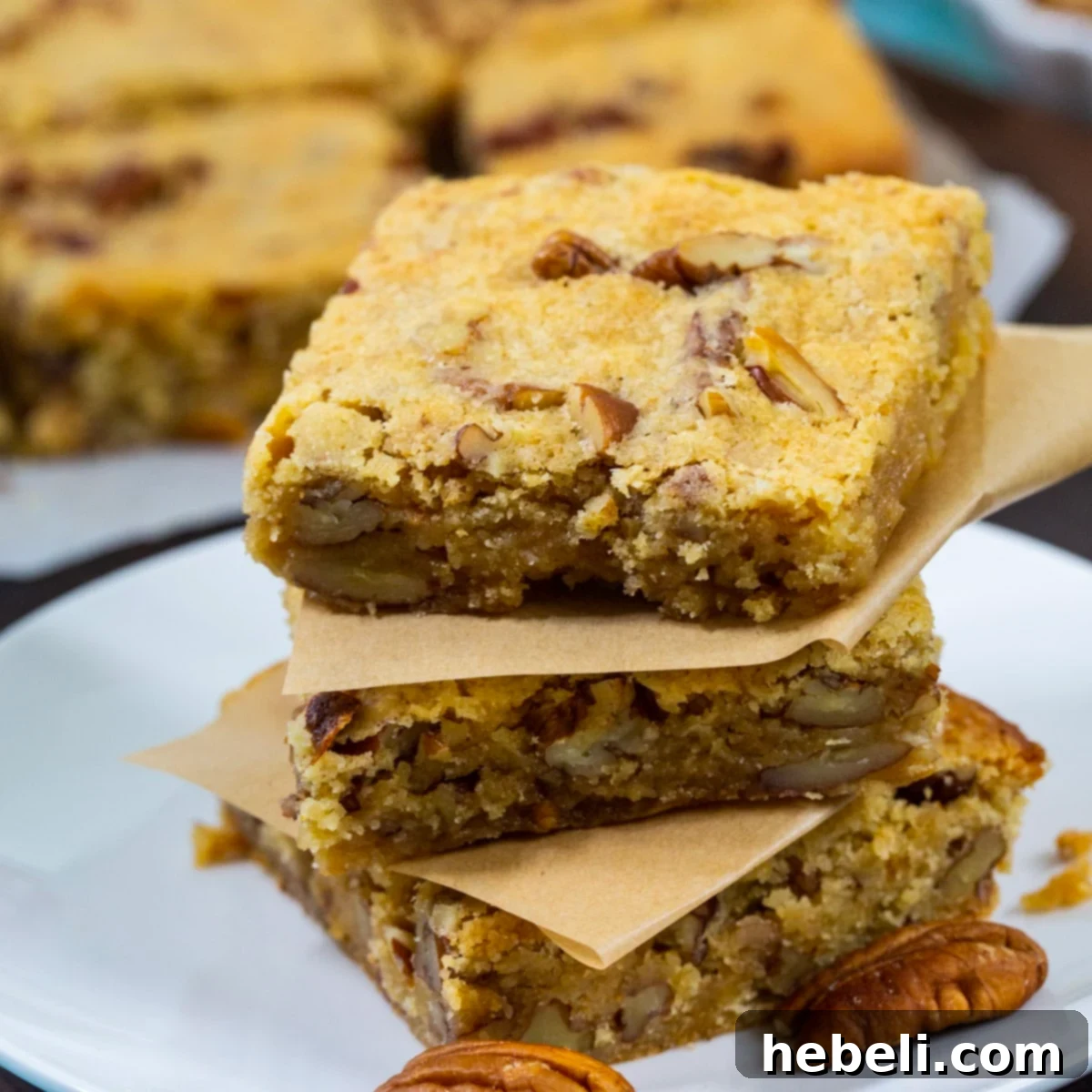Three golden brown Bourbon Pecan Blondies stacked up, showing their chewy texture.