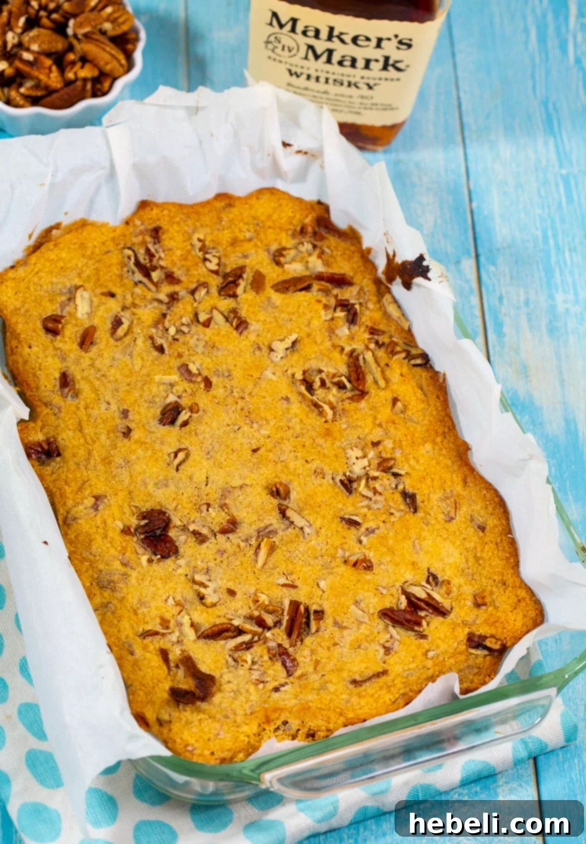 Golden brown blondies resting in a square baking dish, fresh from the oven.