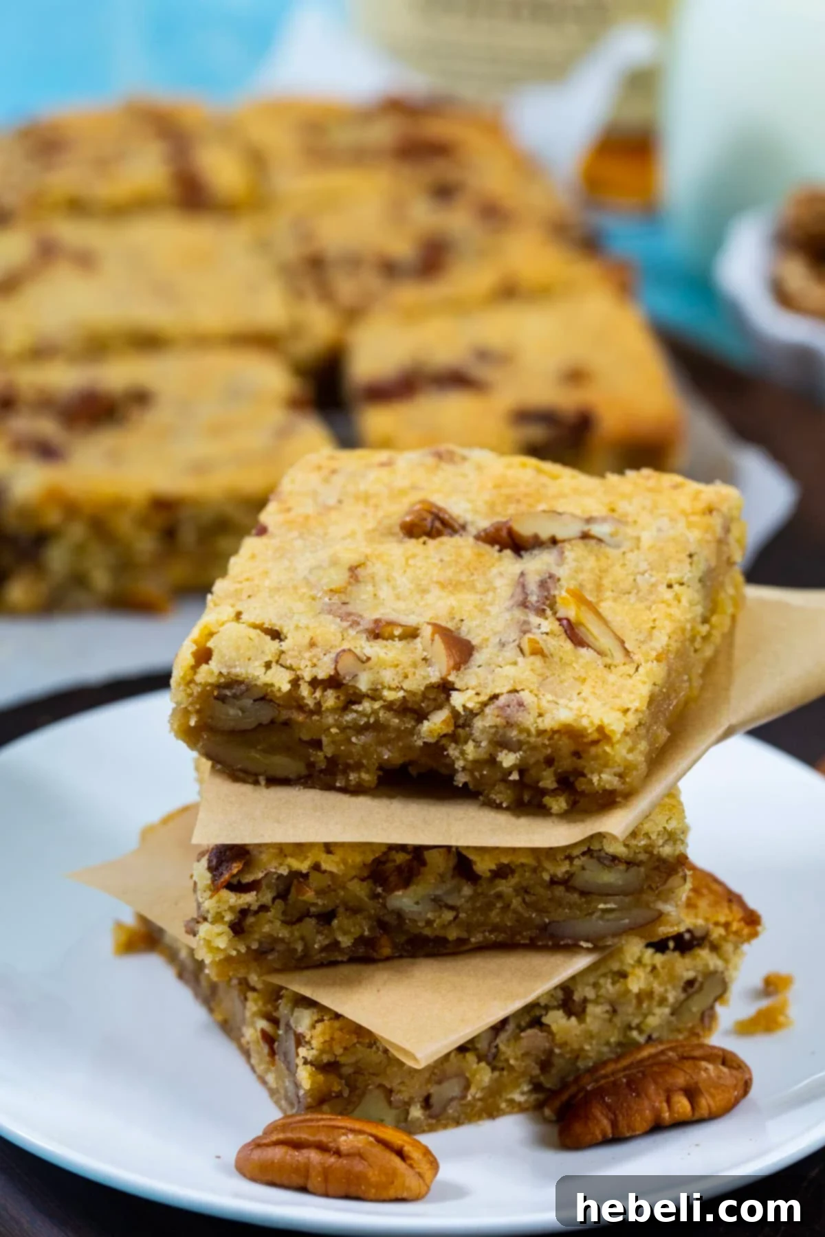 A small stack of Bourbon Pecan Blondies on a dainty plate, ready to be eaten.