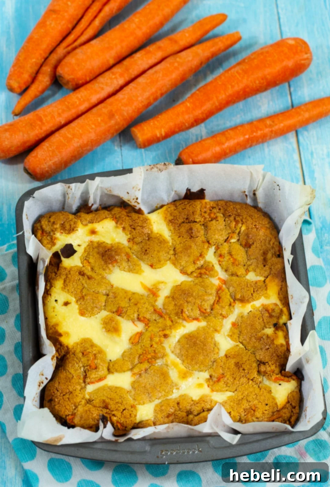 Spiced Carrot Cake Cheesecake Bars 3 Carrot Cake Cheesecake Bars ready in a baking pan, showing the golden-brown top layer before cooling and cutting.