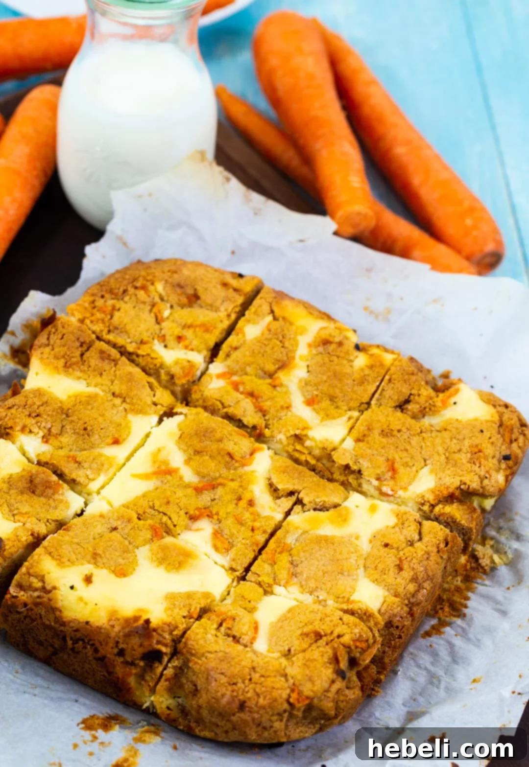 Spiced Carrot Cake Cheesecake Bars 4 Close-up of baked Carrot Cake Cheesecake Bars showing the swirl of cake and cheesecake layers, cut into squares.