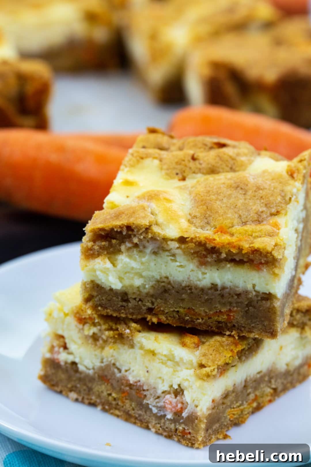 Spiced Carrot Cake Cheesecake Bars 6 Two Carrot Cake Cheesecake Bars stacked on a plate, highlighting their height and delicious layers.