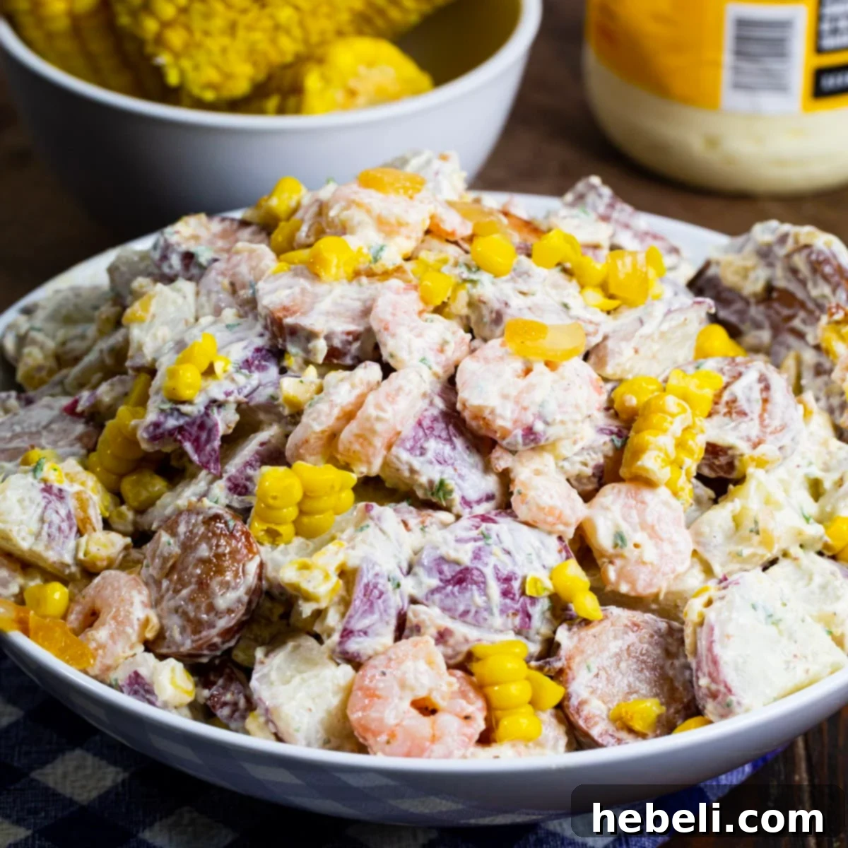 Frogmore Potato Salad served in a large, rustic bowl, garnished with fresh herbs, ready for a gathering.