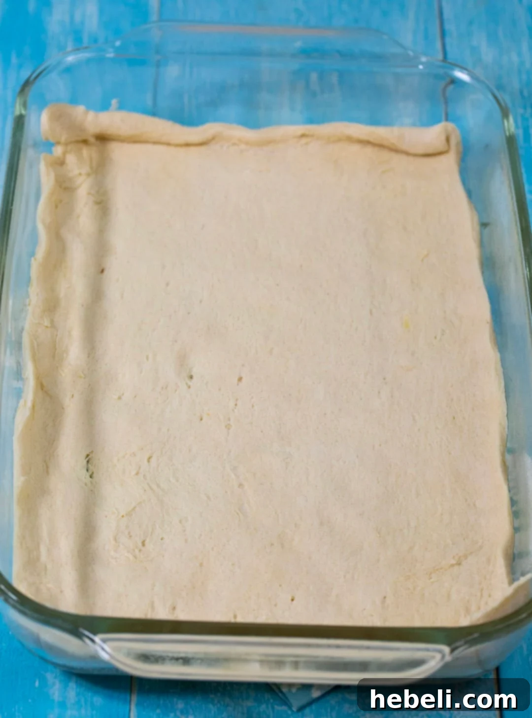 Buttery Crescent Pecan Pie Bars 3 Crescent roll dough unrolled and pressed into a 9x13-inch baking dish, ready for pre-baking.