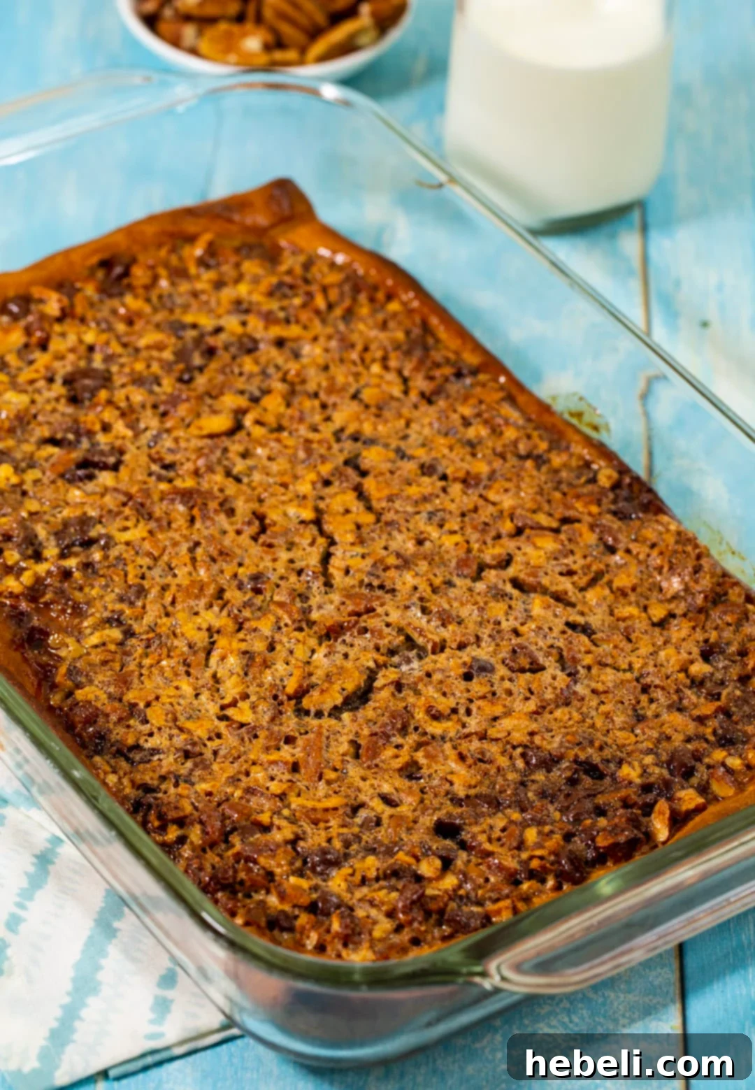 Buttery Crescent Pecan Pie Bars 4 Freshly baked Crescent Pecan Pie Bars cooling in the baking dish, showing a golden-brown crust and caramelized pecan topping.