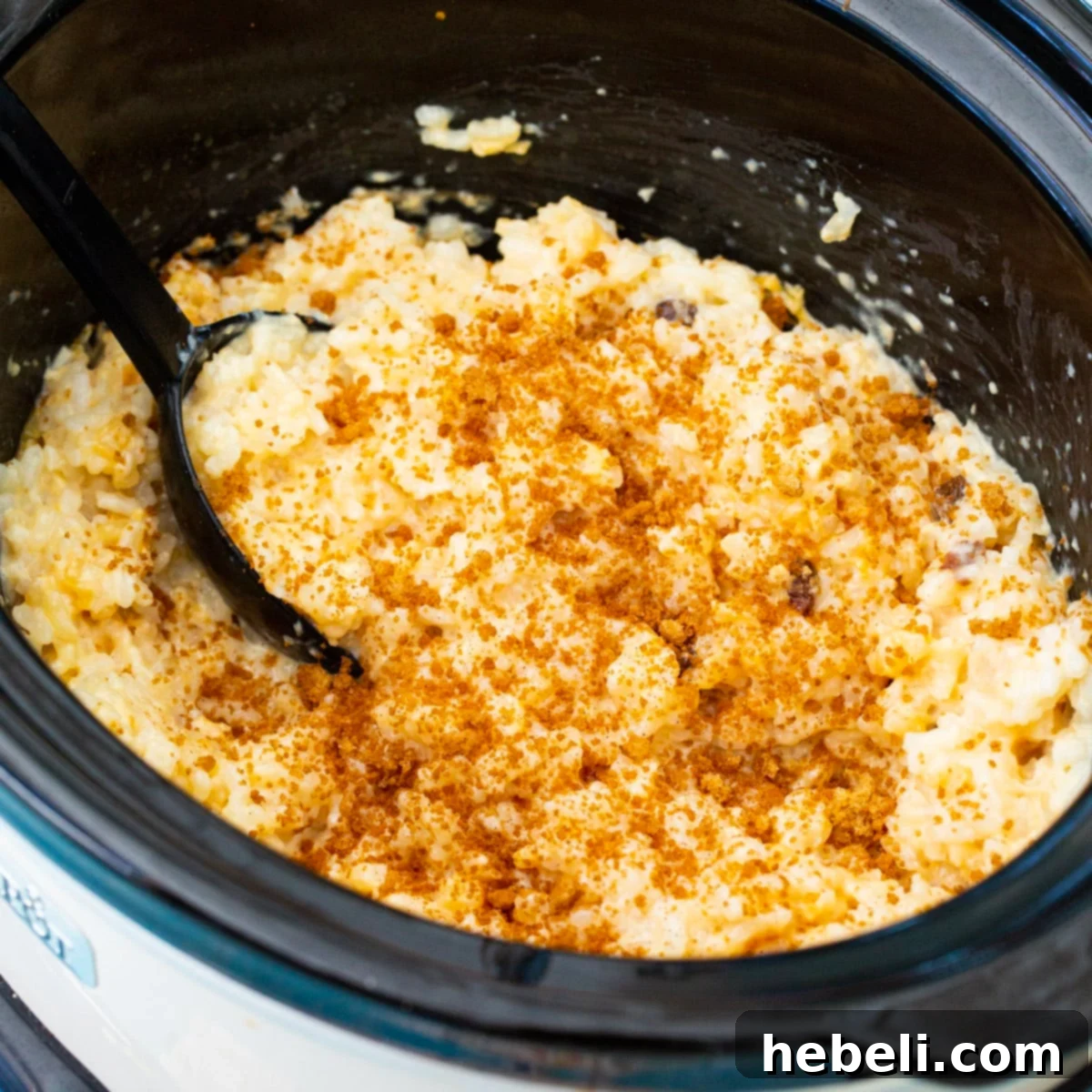 Rich and creamy Slow Cooker Rice Pudding simmering in a slow cooker, ready to be served.