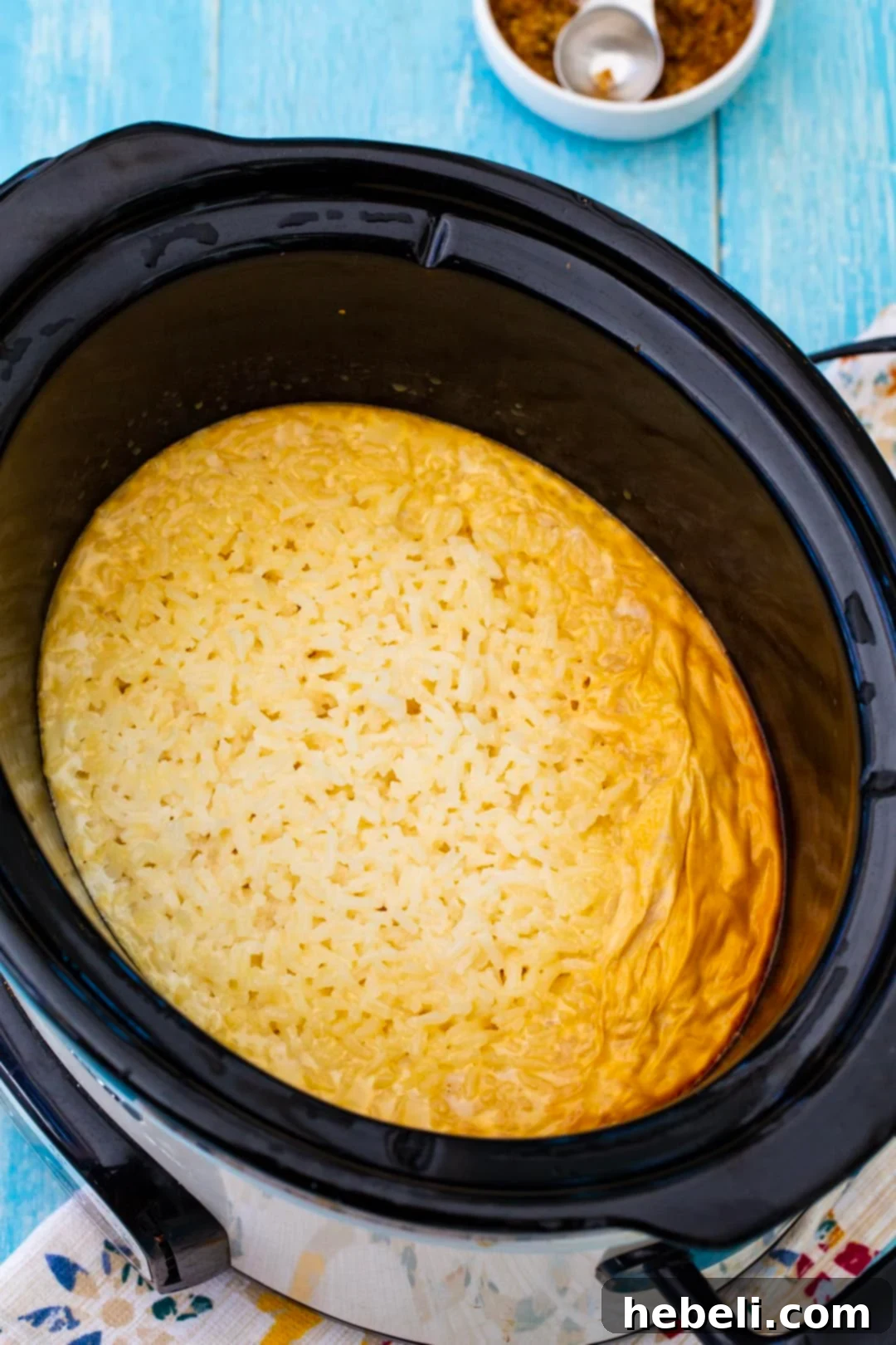 Freshly cooked rice pudding in a slow cooker, showcasing its creamy texture before serving.