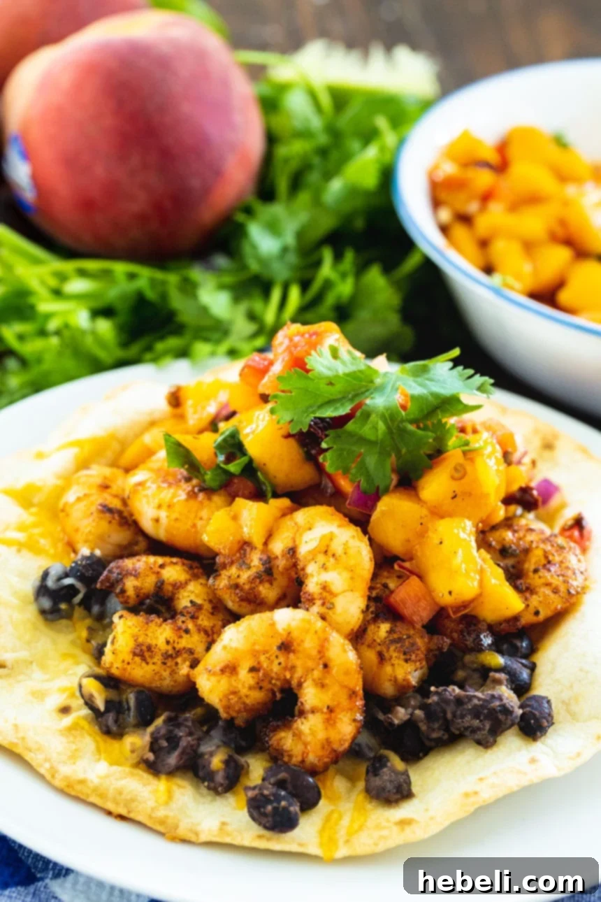 Sweet Peach Shrimp Tostadas 4 Beautifully plated tostada, showcasing the delicious layering of black beans, succulent shrimp, and a vibrant peach salsa.
