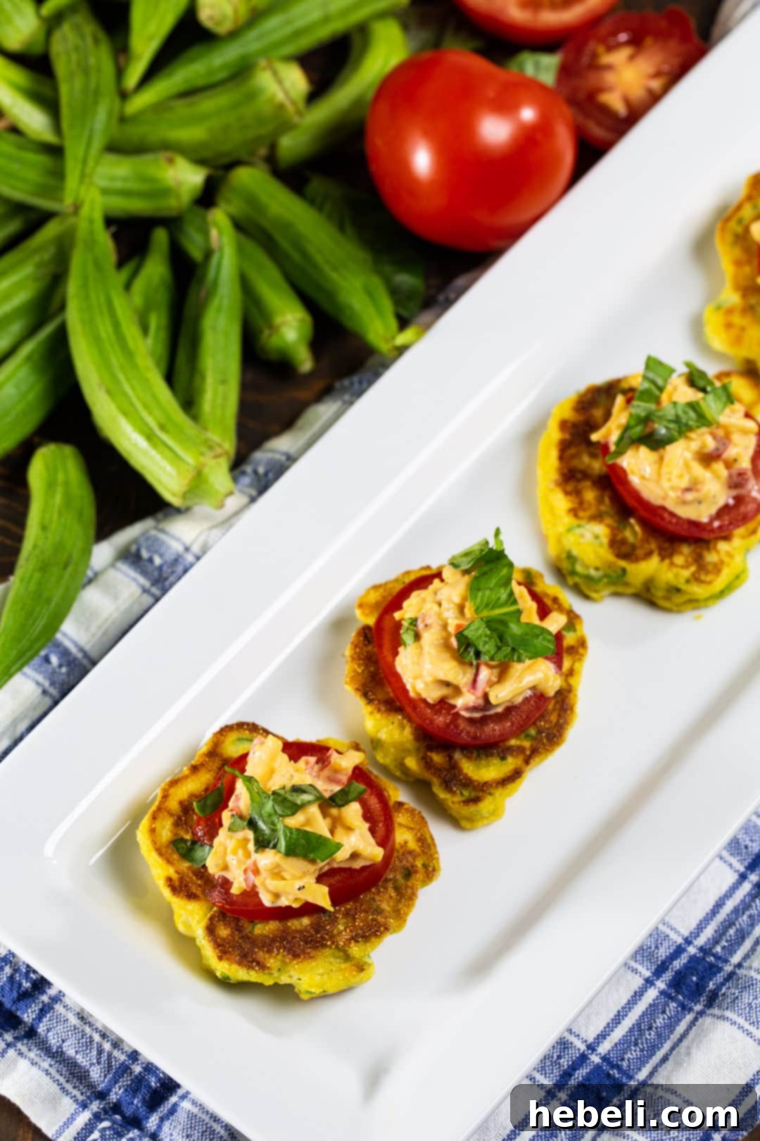 Serving plate with Okra Pancakes with Pimento Cheese, surrounded by fresh, vibrant green okra pods.