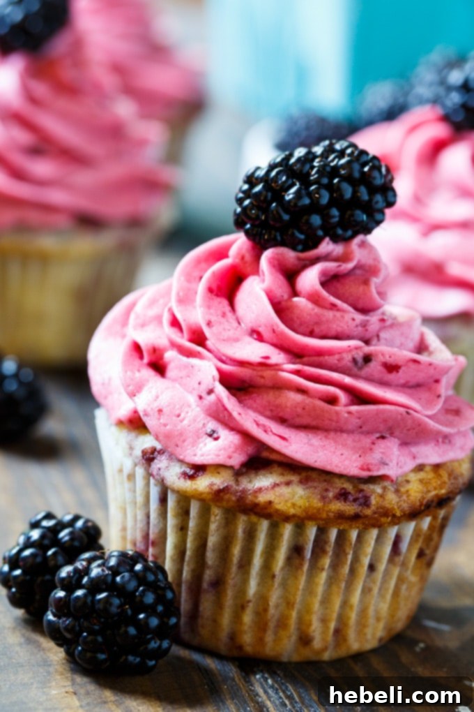 Velvet Blackberry Cupcakes 5 Row of baked blackberry cupcakes cooling on a wire rack, ready for frosting.