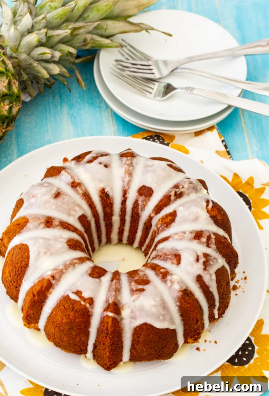 A perfectly baked Pineapple Pound Cake, golden and ready to be sliced, on a clean white plate.