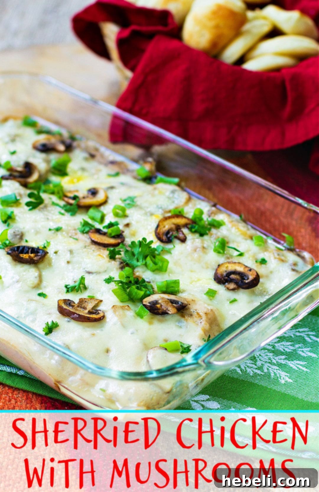 Chicken with Mushrooms in a casserole dish, ready for the oven, with a basket of rolls in the background.