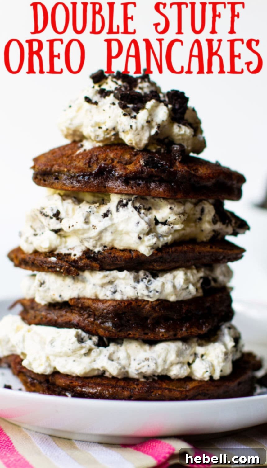 A beautifully plated stack of Double Stuffed Oreo Pancakes with a side of berries and a drizzle of chocolate, tempting to eat.