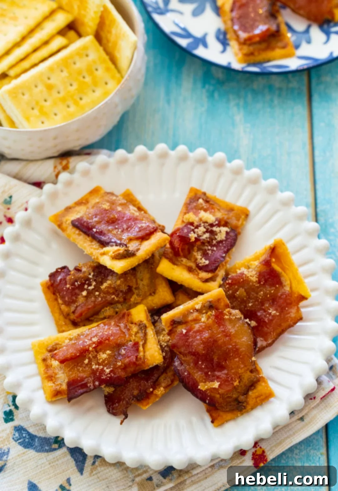 Bacon Boursin Cracker Bites 3 A close-up view of freshly baked Boursin Bacon Crackers served on a rustic wooden board, highlighting their golden crispiness and tempting allure.